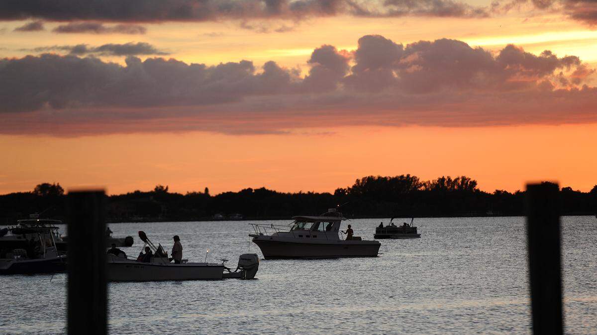As the sun sets, boats wait near the Bradenton Yacht Club in Palmetto Saturday night for the 18th year of the holiday boat parade on Manatee River.TIFFANY TOMPKINS-CONDIE/Bradenton Herald