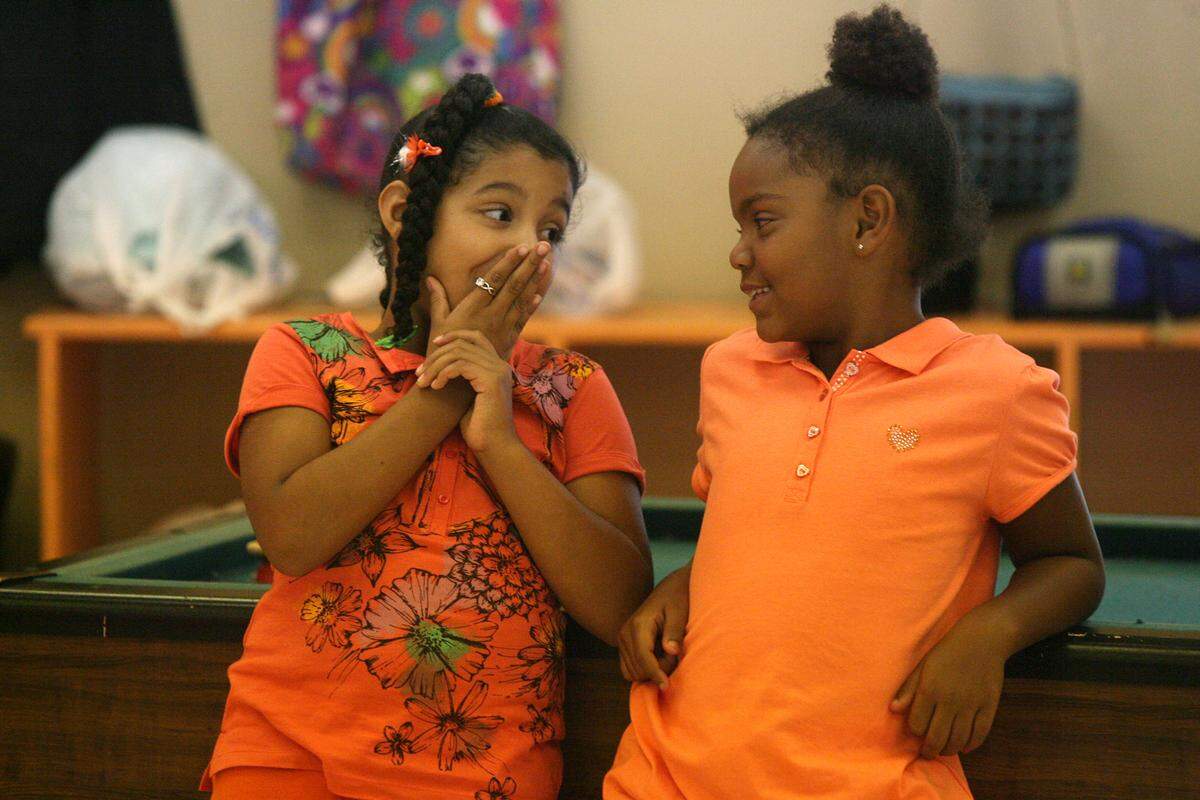 Friends Alexia Washington and Jaylin Charles, both 7, share a secret at the Rubonia Community Center’s summer camp themed “Dare to Dream” in 2011.