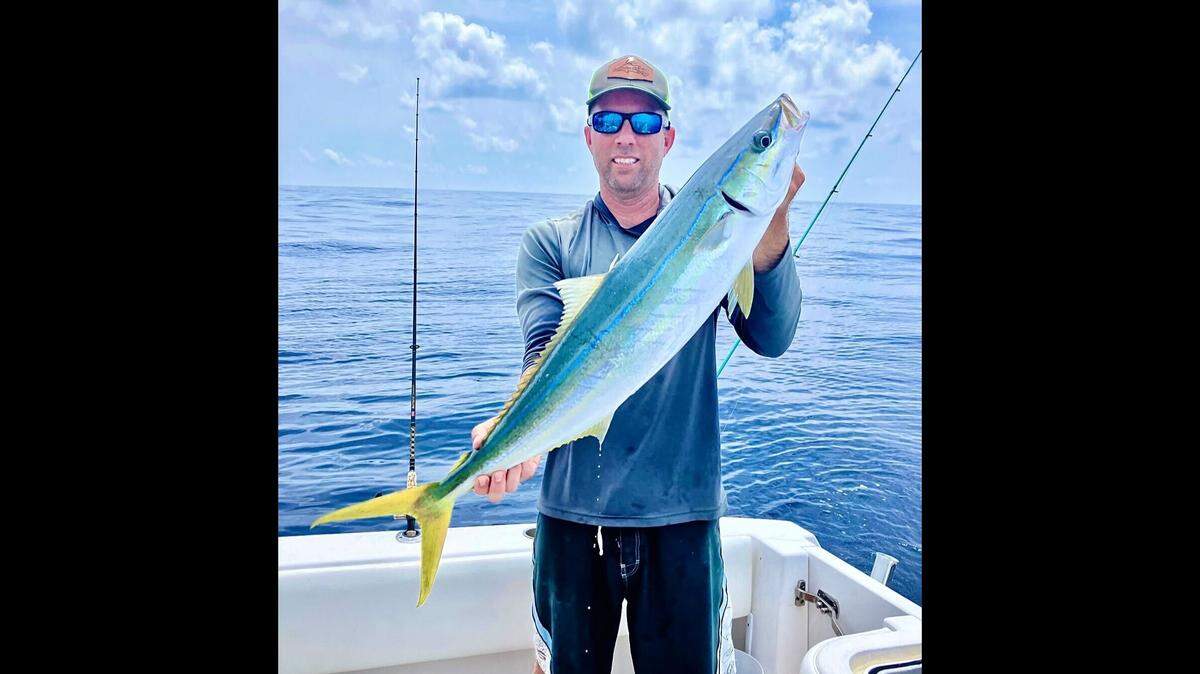 Jon Chapman poses with the rainbow runner caught fishing in the Gulf of Mexico.