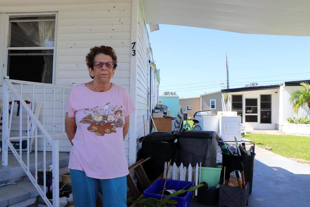 Denise Bruno stands outside her damaged home in Orange Acres in Sarasota, Fla., Oct. 12, 2024, three days after Hurricane Milton passed through Sarasota. Many residents in the manufactured home community are elderly or disabled, Bruno said, which makes it hard to recover from hurricanes. (Kylie Williams/WUFT News)