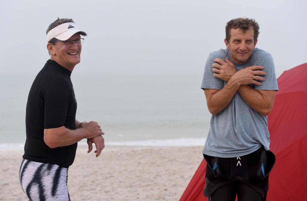 Garry Fenimore and Todd Woods wait for the other swimmers to arrive at the beach. The AMI Swim Club, also known as the Hogfish, had to find alternate swim locations when red tide was present in the waters of Manatee Public Beach. Now they’re back in their home waters.