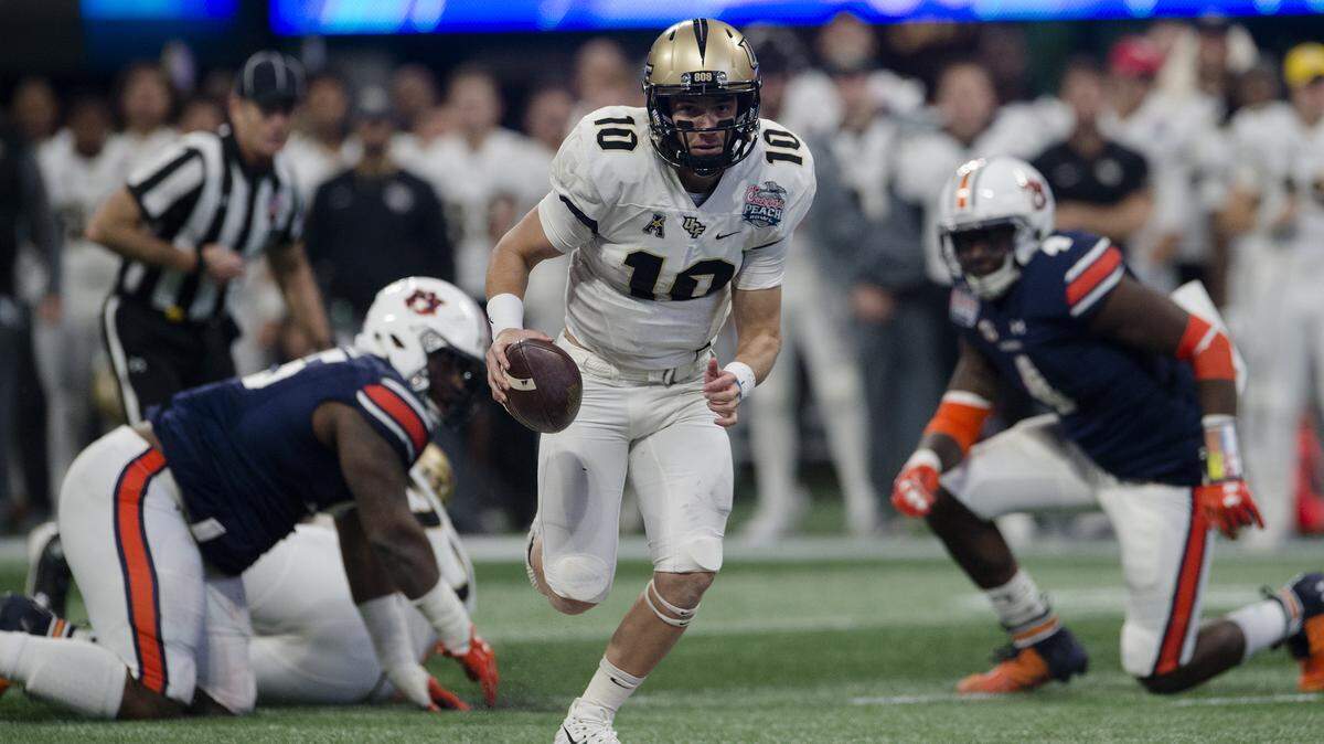 In this file photo, UCF quarterback McKenzie Milton (10) runs for a touchdown against Auburn during the first half of the Peach Bowl NCAA college football game Monday, Jan. 1, 2018, in Atlanta, Ga.