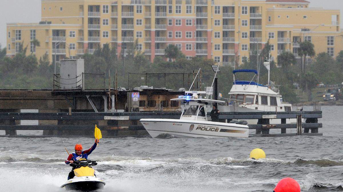 A race official holds up a caution flag after a Hydrocross racer wiped out in the rough river waters during the Bradenton Area River Regatta Saturday. 
 TIFFANY TOMPKINS/Bradenton Herald