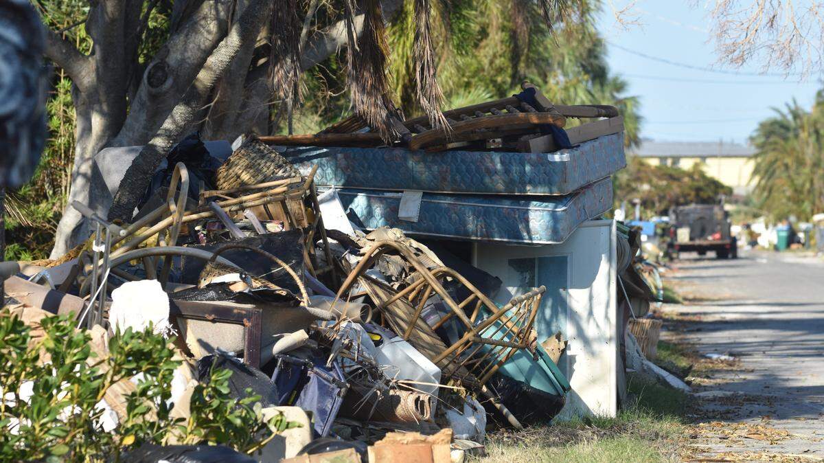 In October, storm debris piles in front of homes on Anna Maria Island after the Manatee County barrier island was slammed by two back-to-back hurricanes — Helene and then Milton.