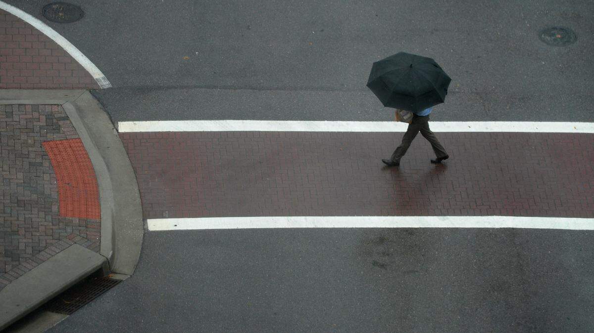 A man walks across the road Wednesday as rain and storms move through Manatee County. 
 GRANT JEFFERIES/Bradenton Herald