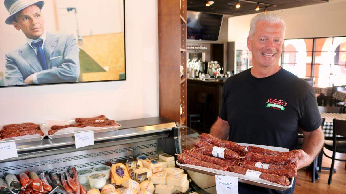 Gary Blake holds a tray of dry Italian sausages Feb. 24, 2023, at Adolfo’s Italian Market and Pizzeria, 8225 Natures Way, Lakewood Ranch.