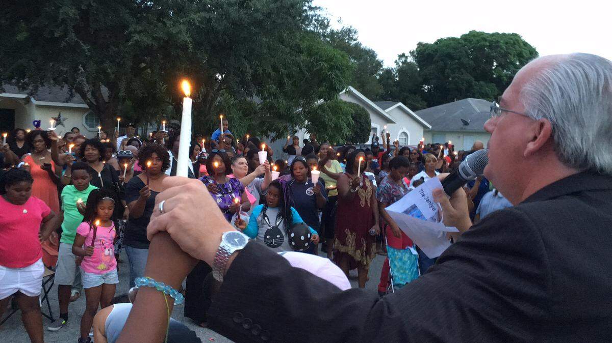 The Rev. Bill Bailey, right, of Happy Gospel Church, holds a candle as he speaks to the crowd during an emotional candlelight vigil Sunday night for Janiya Thomas, the 11-year-old girl whose body may have been found in a freezer eight days ago. The vigil was held in the 5000 block of 21st Way East in Manatee County and was organized by Palmetto resident Wayne Washington who has vowed not to let Janiya be forgotten. 
 RICHARD DYMOND/Bradenton Herald