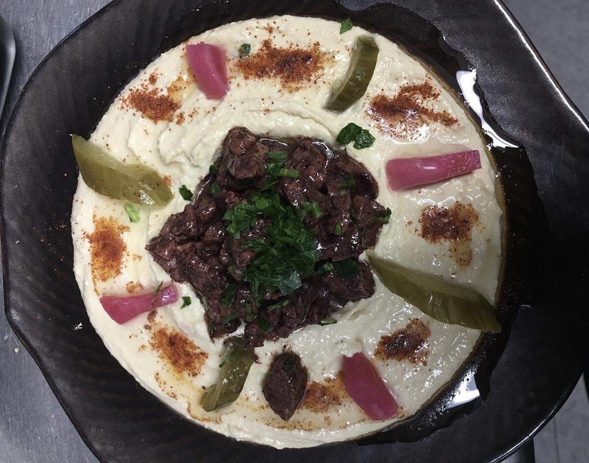 Hummus, a Middle Eastern appetizer with chick peas and  tahini served with pickles and beef shawarma, is offered at Tahini Beach Cafe in Bradenton Beach.