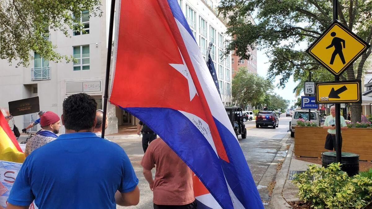 Protesters marching down Main Street in downtown Sarasota calling for American intervention in Cuba to give the country freedom from the totalitarian communist dictatorship.
