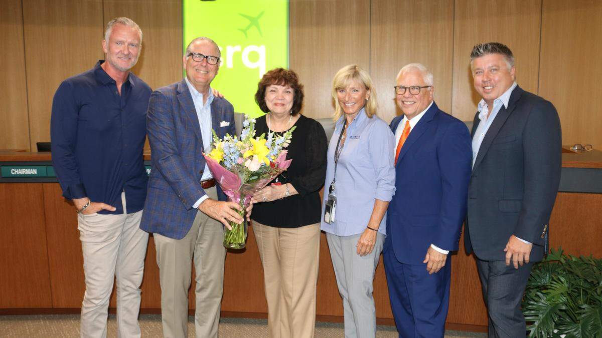 9/27/2021--Karen Garofalo (center), executive assistant at Sarasota Bradenton International Airport, attended her last Sarasota Manatee Airport Authority meeting on Monday and was showered with praise and flowers. She first went to work at the airport in 1984. Shown above are airport authority members, from left, Jeff Jackson, Bob Spencer, Karen Garafalo, Kristin Incrocci, Carlos Beruff, and Jesse Biter.