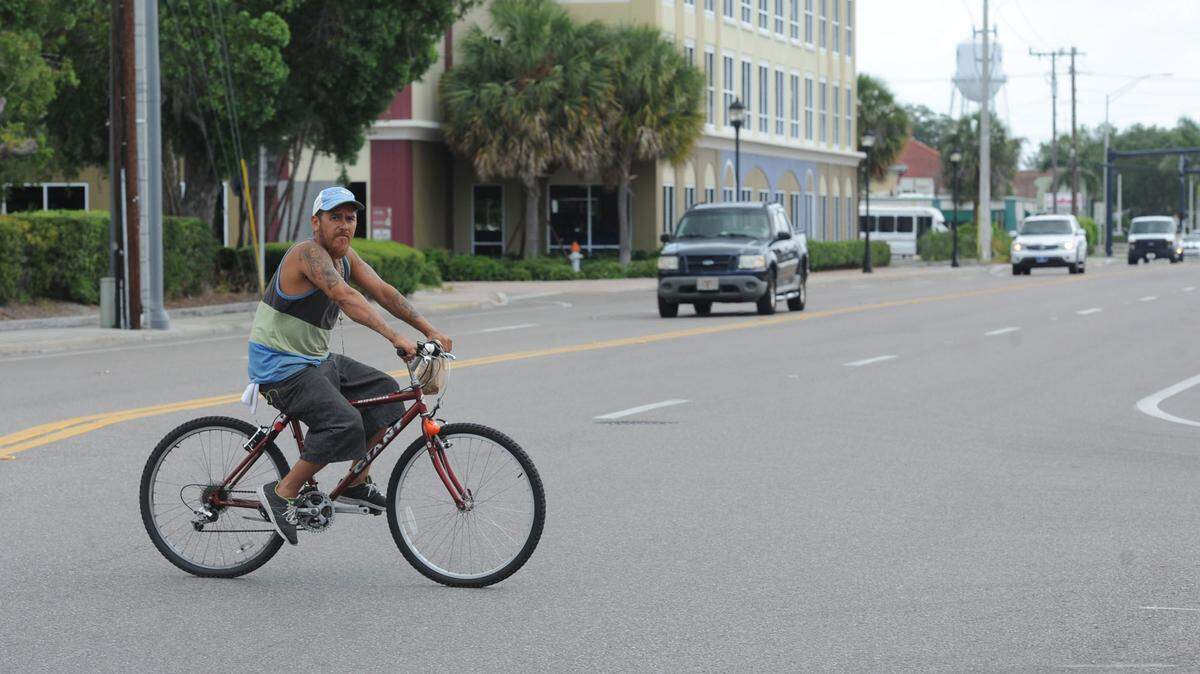 A bicyclist rides across Eighth Avenue West in Bradenton. FDOT could begin construction of a pedestrian safety project along Eighth Avenue West from Ninth Street West to 14th Street West in about 18 months. The project is to include turn lanes, crosswalks and medians. 
 GRANT JEFFERIES/Bradenton Herald