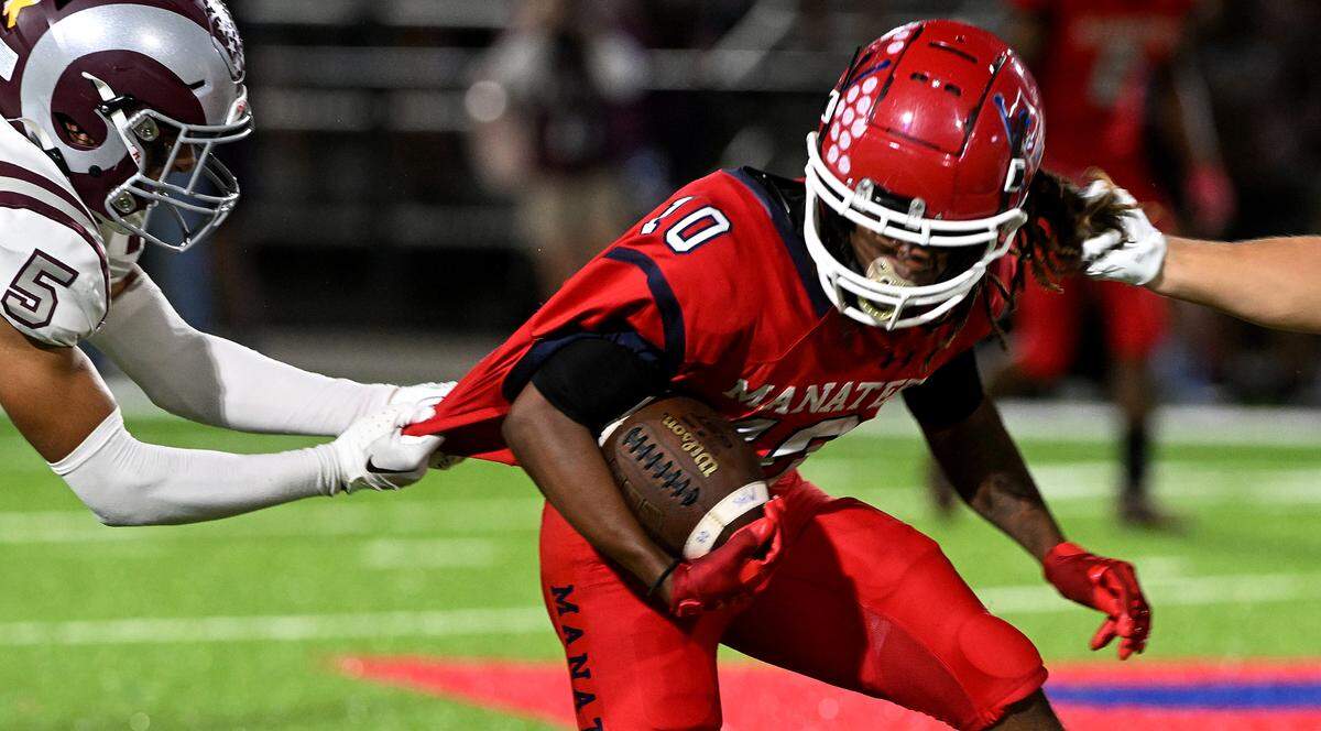 Manatee’s Bon Bean, Jr. gets grabbed on two sides while playing Sarasota Riverview at Joe Kinnan Field at Hawkins Stadium on Friday, Nov. 17, 2023.