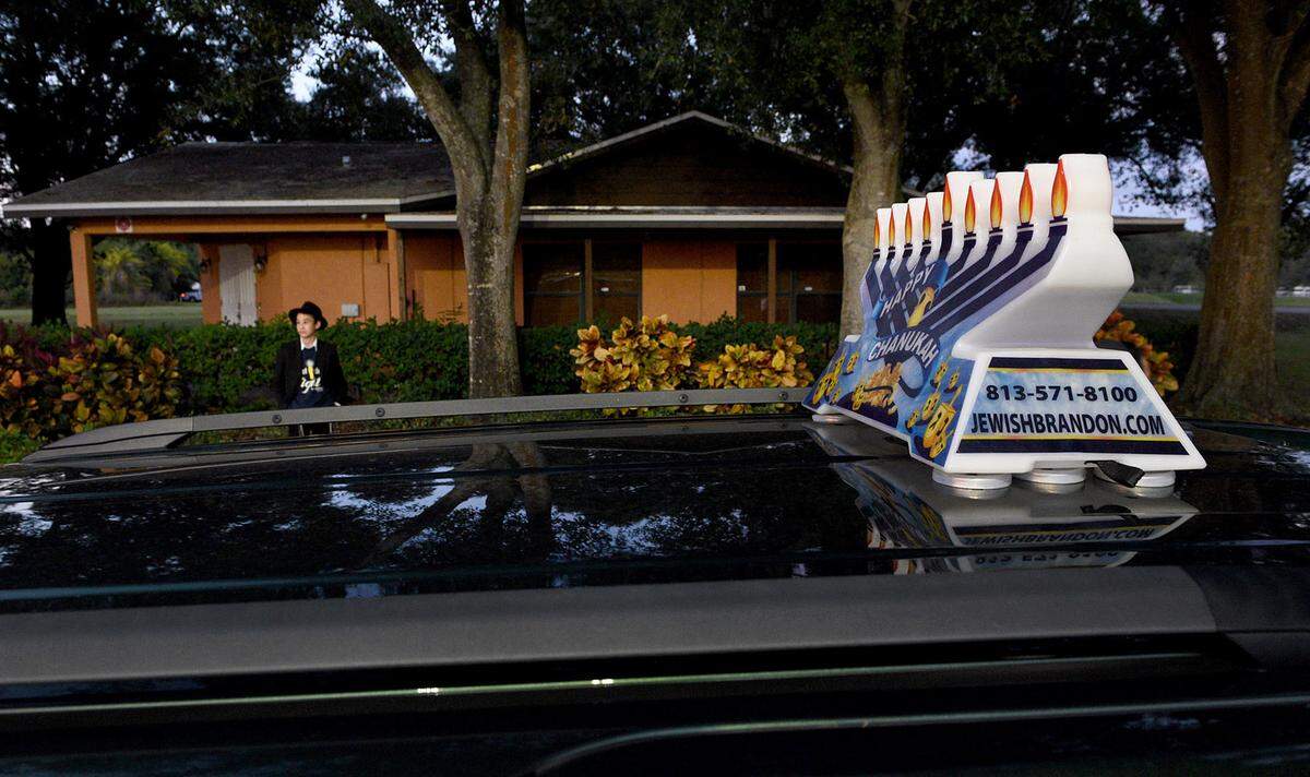 12/01/21—A young members of the Chabad of Bradenton watches as cars install lit menorahs on their rooftops to celebrate the 4th night of Hanukkah.