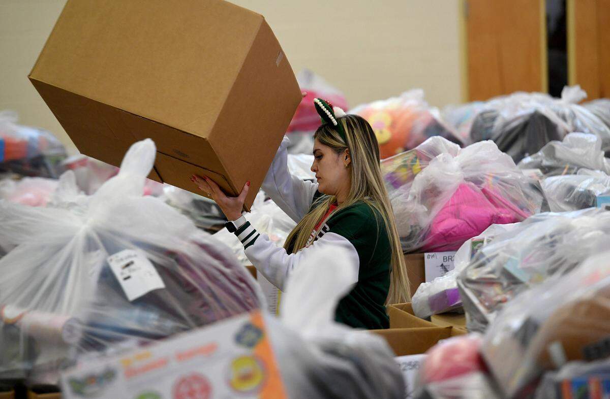 Volunteer Maria Diaz works with dozens of volunteers to gather toys that were collected for 786 families on the Salvation Army’s Angel Tree Distribution Day. Families registered in September to receive presents for their children along with a turkey or ham. The distribution was drive-through style, with volunteers working together to make the event run smoothly.