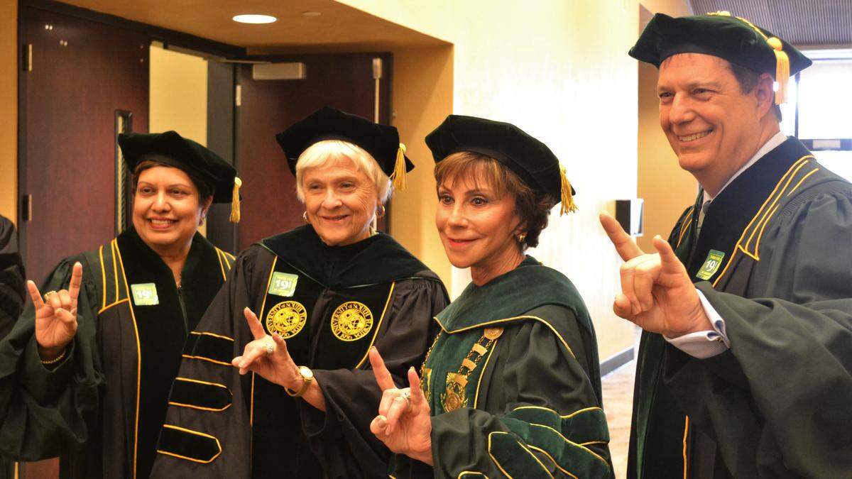 USF system president Judy Genshaft, second from right, poses with University of South Florida Sarasota-Manatee staff and faculty before the graduation ceremony.