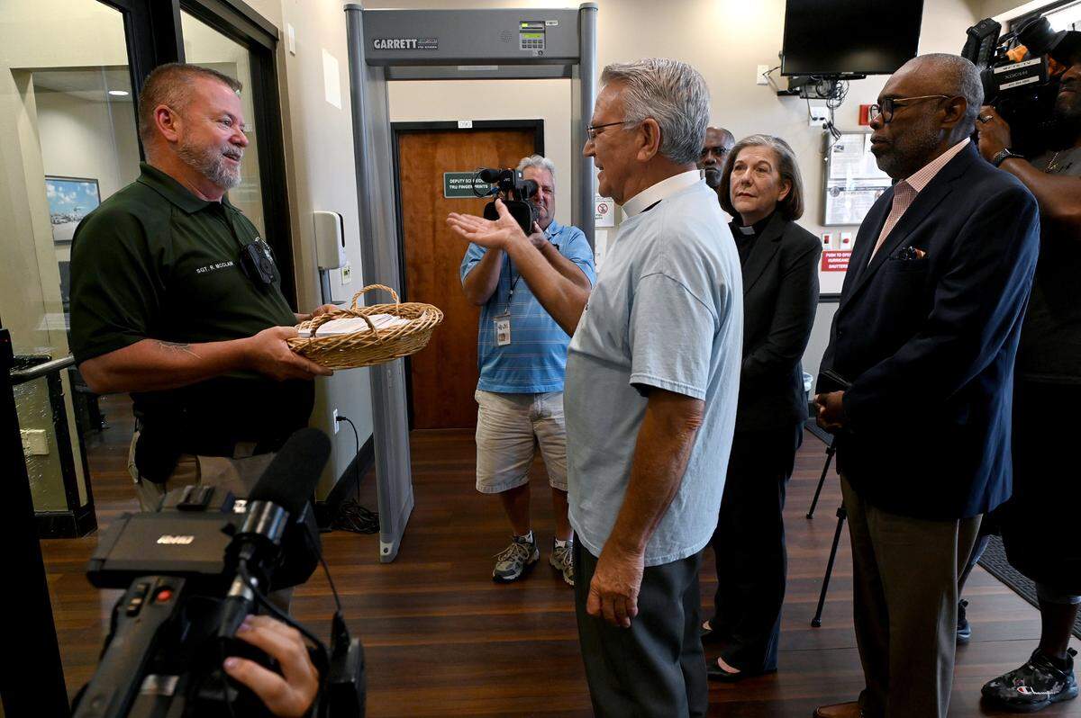 Fr. Glen Graczyk of St. Mary’s Episcopal Church in Palmetto with Ossie Reid of Harvest United Methodist Church and Rev. Kim Uchimura, Sr. Pastor at Emmanuel United Methodist Church deliver hundreds of letters in support of a pre-arrest diversion program to Sgt. Rick McLain for Manatee County Sheriff Rick Wells.