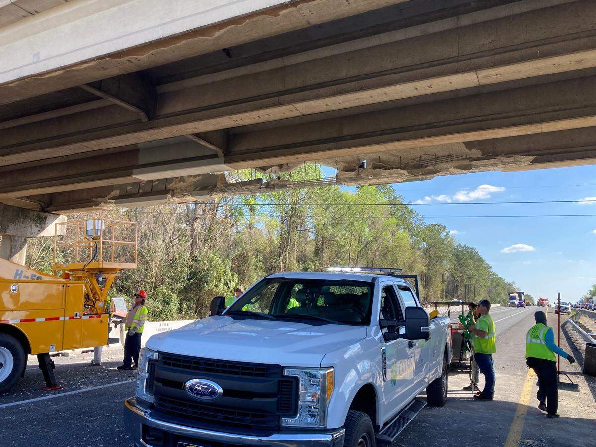 Florida Department of Transportation workers clear the road after a tractor trailer carrying an oversized load ran into an overpass in Marion County near Ocala on Wednesday, Feb. 22, 2023.