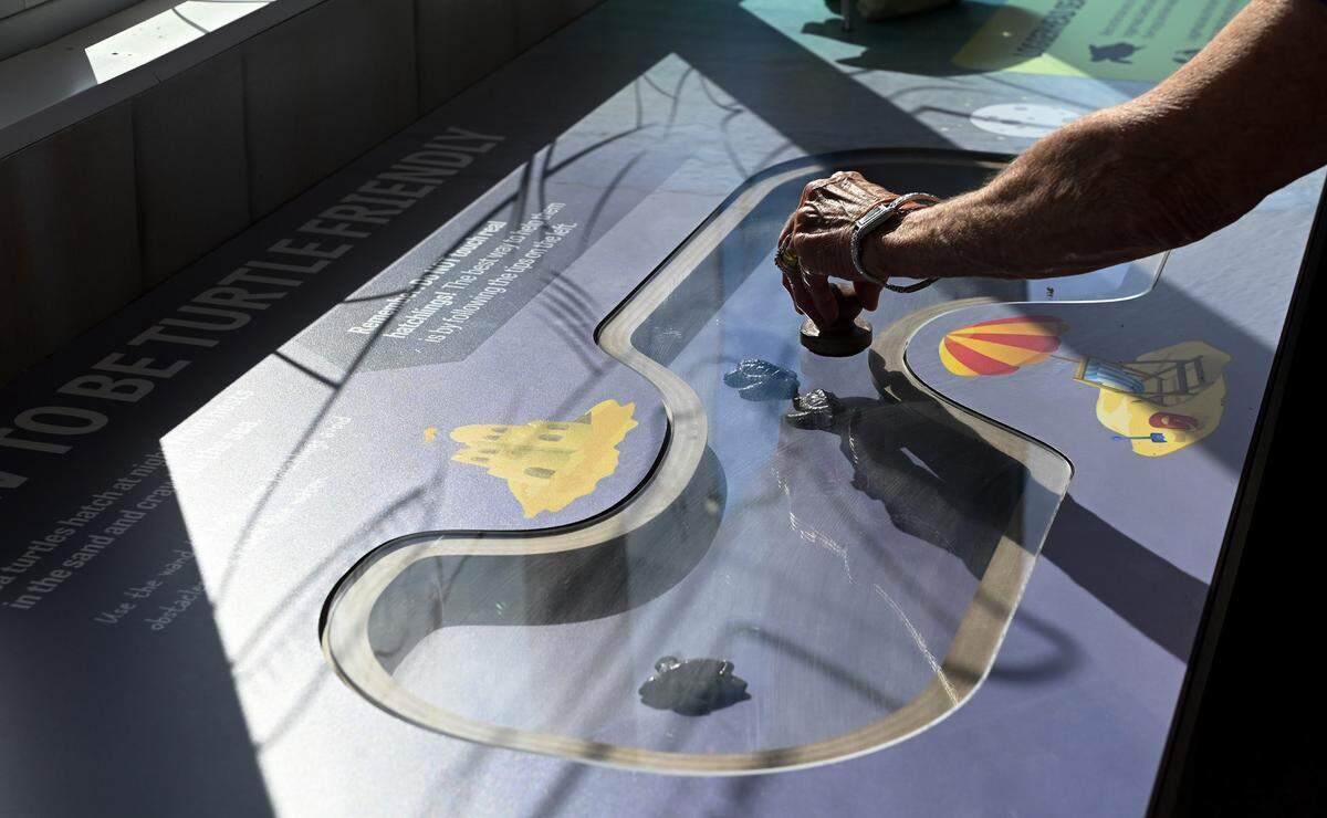 Barbara Murphy tries out an interactive exhibit during a preview of the Mote Marine Laboratory & Aquarium which opens its Anna Maria outreach and education center this week on the Anna Maria Pier.