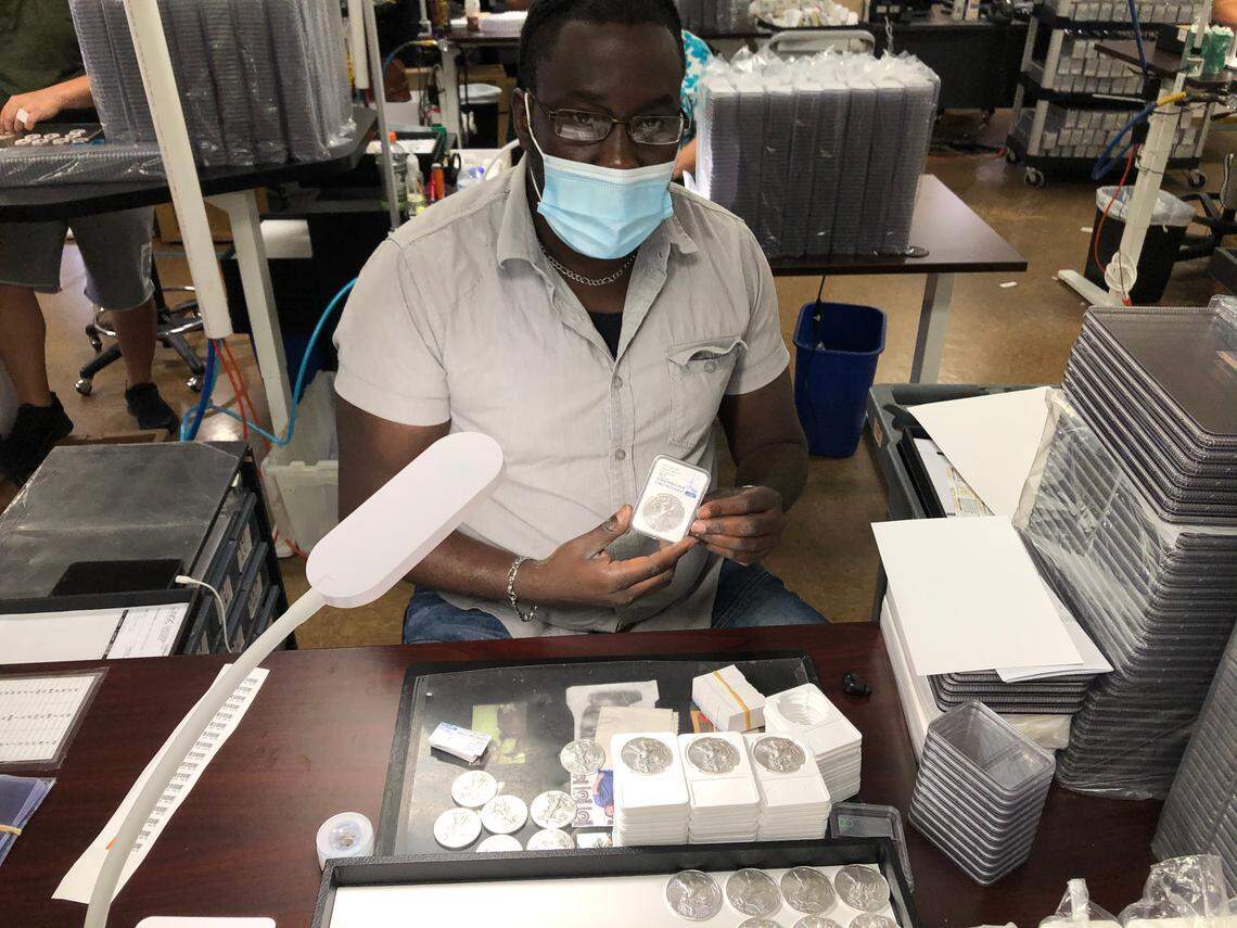 6/3/2021--A staff member at Certified Collectibles Group encapsulates 2021 American Silver Eagle coins. The company plans to add 100 employees by the end of summer, bringing its Lakewood Ranch workforce to 500. &nbsp;To hit this target, CCG is offering a $2,500 sign-on bonus for new employees who start by Sept. 30. 