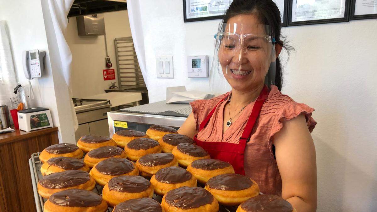 Lin Teav holds a tray of freshly made Bavarian cream doughnuts at the recently reopened Gold Star Donuts, 1246 Whitfield Ave., in the Whitfield Square shopping center.
