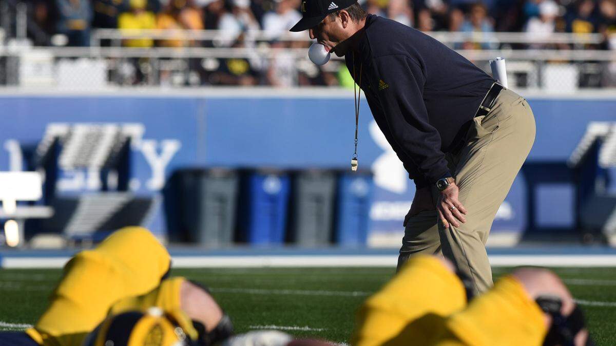Michigan head coach Jim Harbaugh blows a bubble during Friday's practice at IMG Academies which was open to the public. 
 TIFFANY TOMPKINS/Bradenton Herald