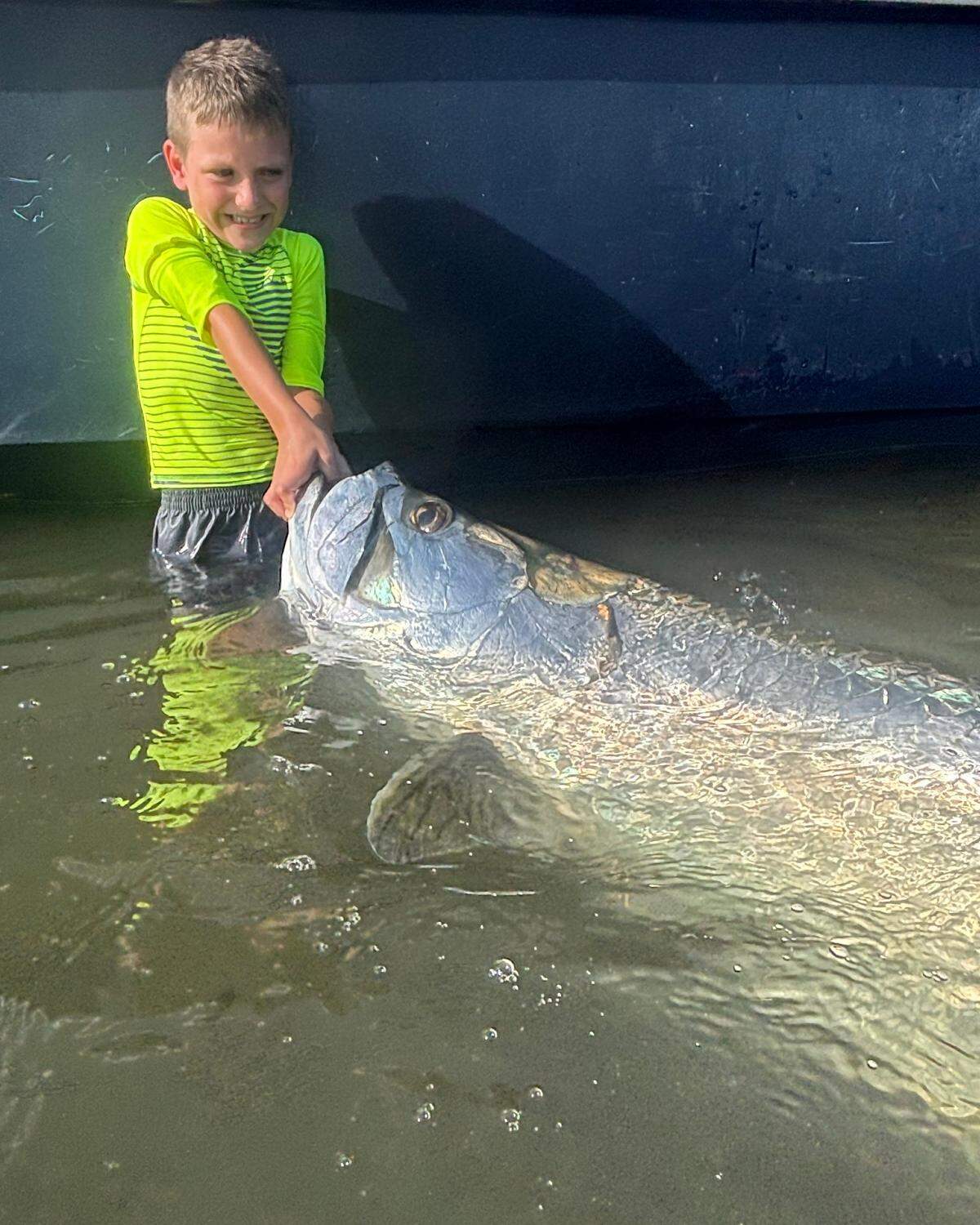 Decker Deans, 7, poses with a tarpon caught while he was first mate on a fishing charter with his dad Griffin Deans, a Palmetto-based charter captain.