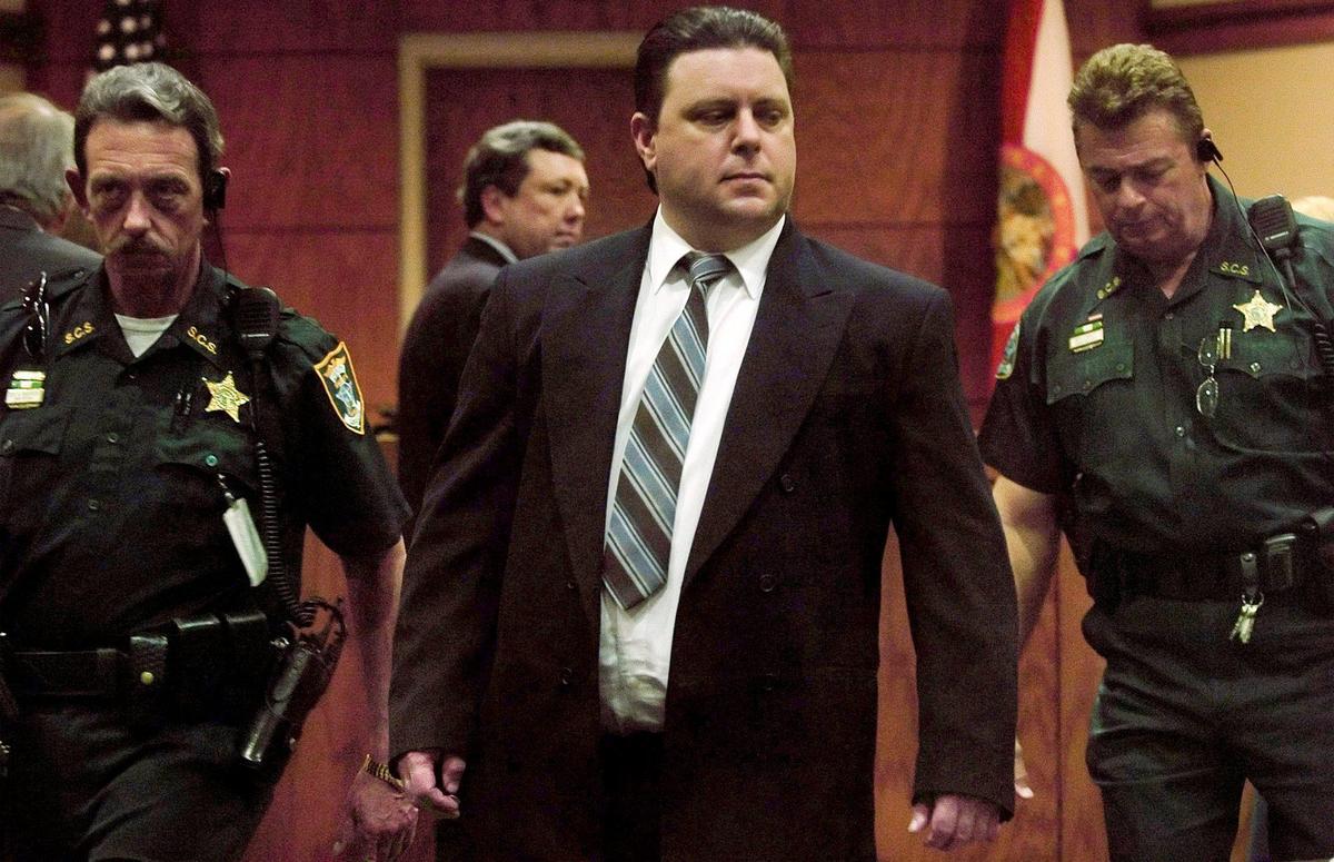 ** FILE ** Joseph Smith is escorted by bailiffs as he heads back to his seat after speaking in sidebar with the judge and his public defender, Adam Tebrugge, background, during the penalty phase of his trial at the Sarasota County Judicial Center in this Wednesday, Nov. 30, 2005 file photo, in Sarasota, Fla. Smith should be executed for kidnapping, raping and murdering Carlie Brucia, the 11-year-old girl whose abduction was captured by a surveillance camera and broadcast around the world, a jury recommended Thursday, Dec. 1, 2005.