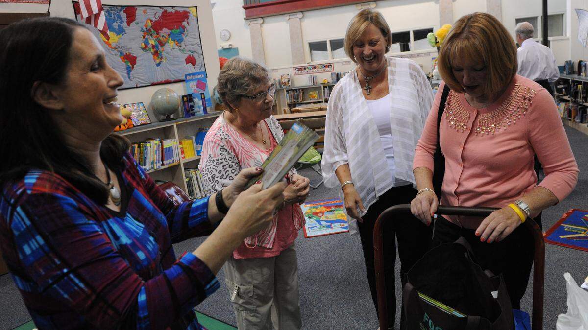 Media specialist Terri Rohde looks through some of the donated books from Cissie Angelo, Debbie Lewis and Melissa Gurchiek with Harvest United Methodist Church women's group. 
 GRANT JEFFERIES/Bradenton Herald