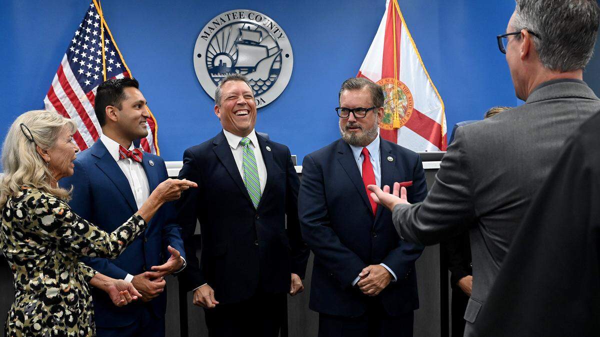 Manatee County Commissioners Carol Ann Felts, Tal Siddique, George Kruse and Mike Rahn share a laugh after a swearing-in ceremony in the chambers.