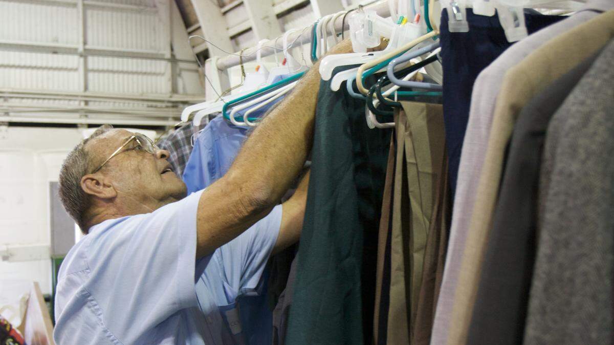 Volunteer Larry Burnette tries to find the right size jacket during Manatee County's Stand Down event at the Manatee County Fairgrounds in Palmetto. Burnette, an army veteran, was among the many volunteers from various organizations helping provide services for the homeless. 
 HERALD FILE PHOTO