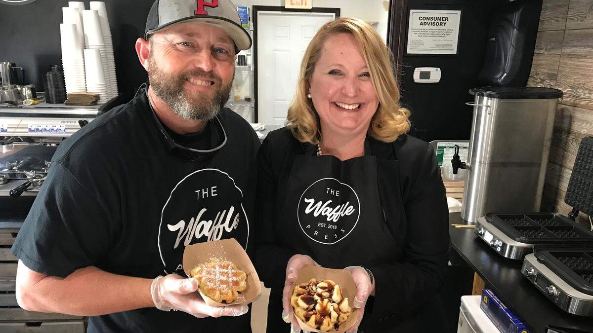 The Waffle Press partners Scott May and Kellie Potter hold samples of their waffles. May holds “The Purist,” a waffle with powered sugar on top, while Potter holds a “Grand Slam,” a waffle topped with bananas, peanut butter and chocolate. The new business is located at 425 Pine Ave., Anna Maria.