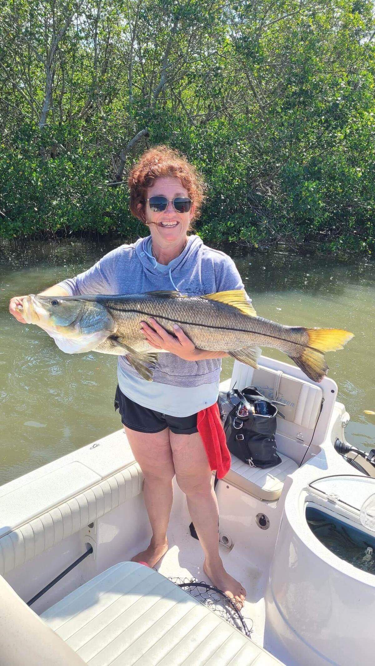 Tanya Johnson poses with the 42-inch snook she caught fishing in Tampa Bay with Capt. Anthony Rufo on Wednesday, March 29, 2023.