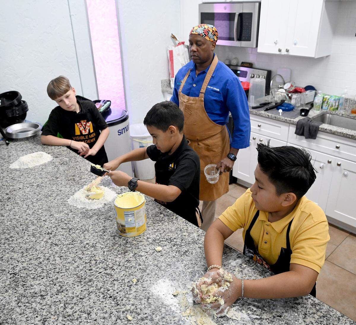 5th-grade students at Visible Men Academy learn how to make apple pies for Thanksgiving from celebrity chef Marvin Woods.