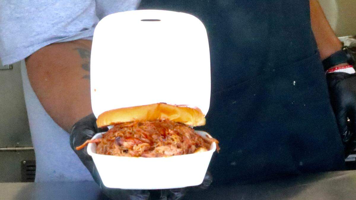 Ty Martin piles the pulled pork high on his sandwiches. The portions are large, says the owner-operator of Ty’s Golden Hog food truck and catering service.