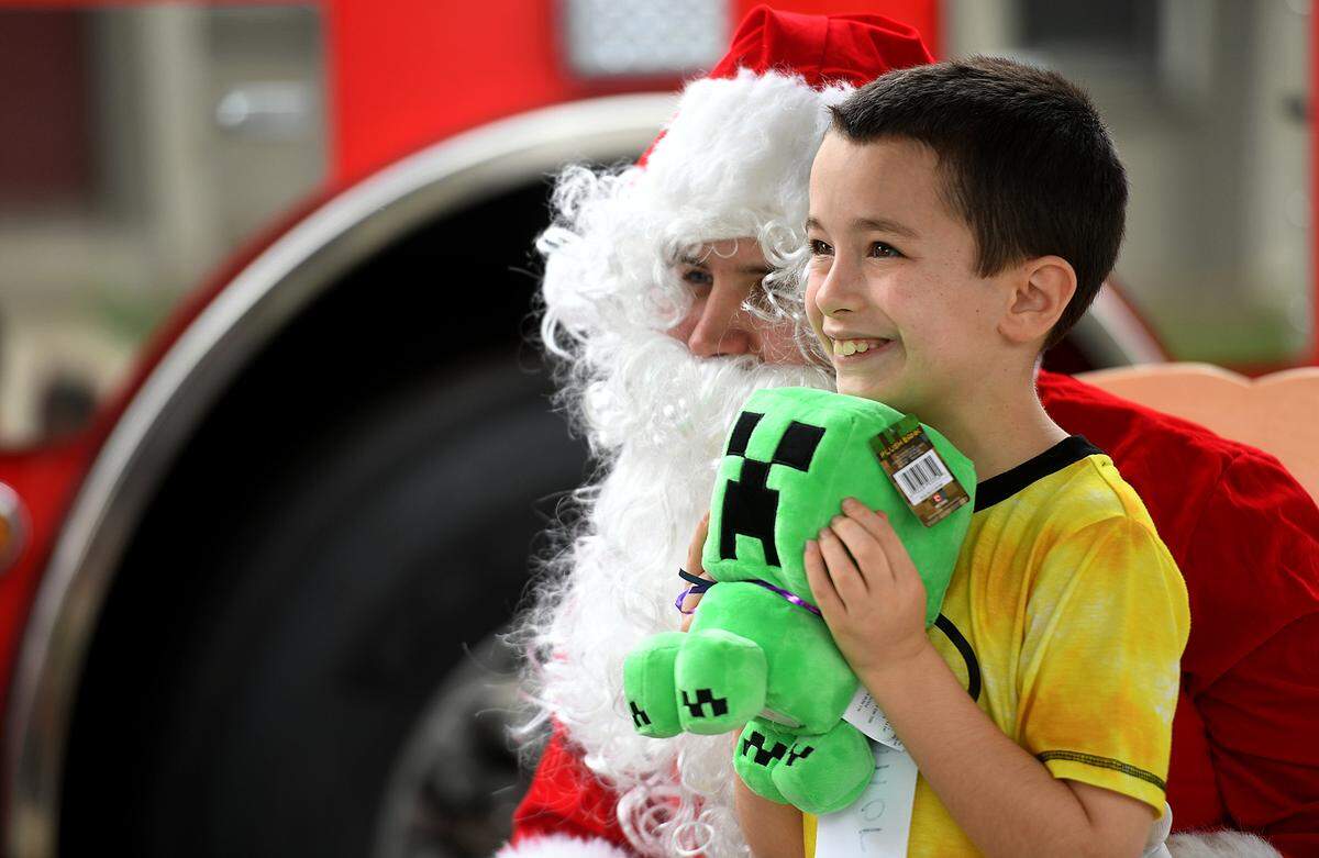 12/20/21—Connor Brandt smiles after getting a toy from Santa, who arrived on an East Manatee Fire Rescue truck at Bashaw Elementary School.