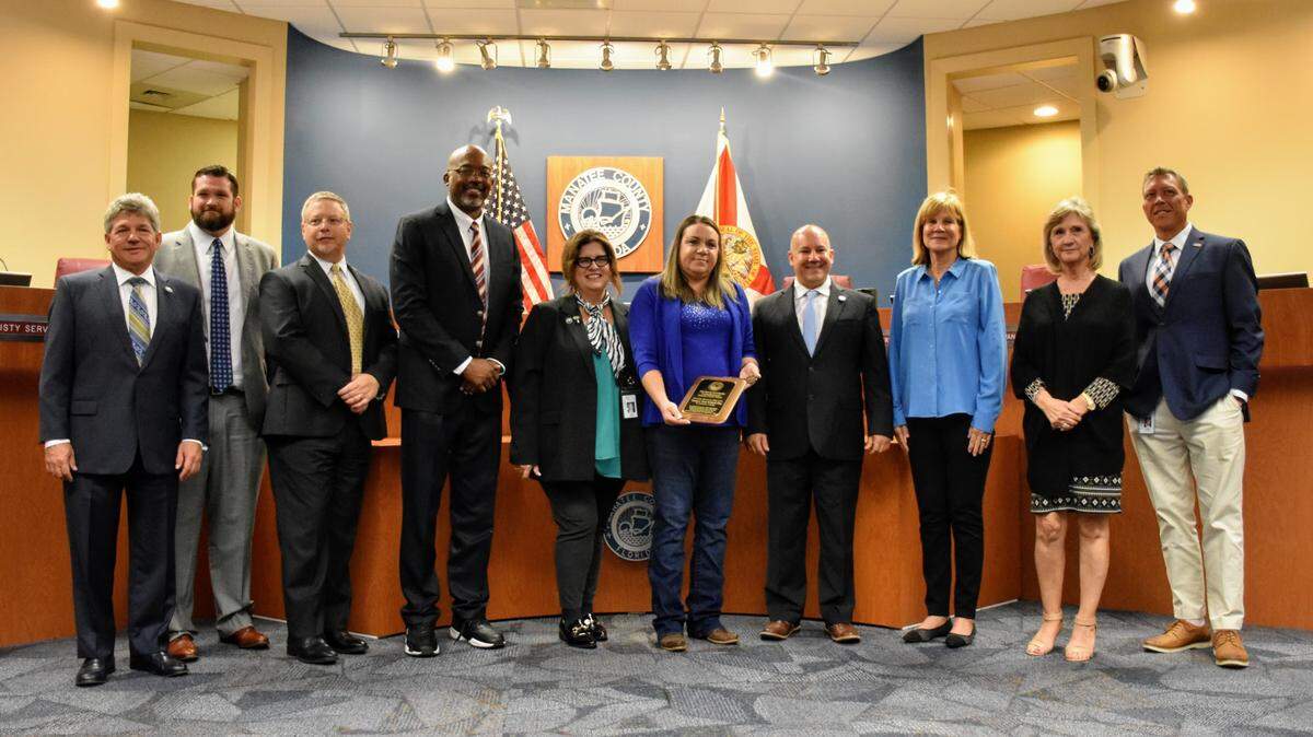 Florida Highway Patrol Trooper Toni Schuck (sixth from the left) poses with the Manatee Board of County Commissioners on Tuesday, March 22, 2022, which has been declared “Toni Schuck Day” after she used her FHP vehicle to prevent a deadly crash during the annual Skyway 10K race on March 6, 2022.