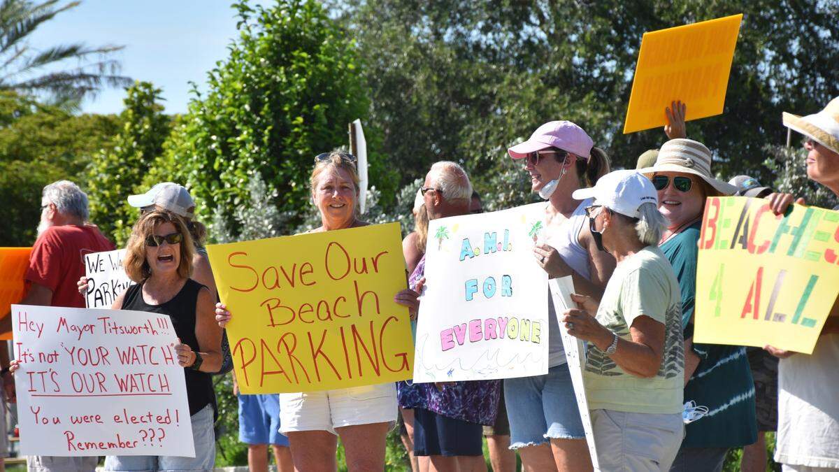 More than 80 residents and visitors stood outside Holmes Beach City Hall, 5801 Marina Drive, Tuesday evening to protest the city’s new beach access parking plan, which removes 1,100 spaces that are within a quarter-mile of the beach.