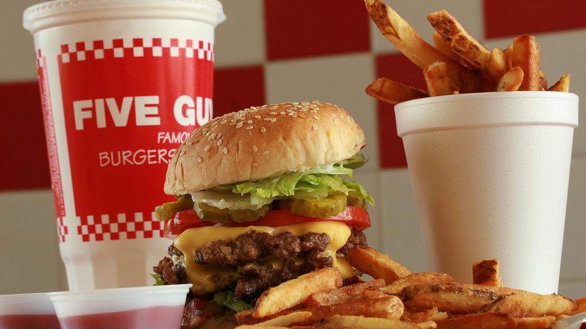 A bacon cheeseburger at FIve Guys Burgers is stuffed to the gills with ample toppings and served with fresh-cut french fries. HERALD FILE PHOTO