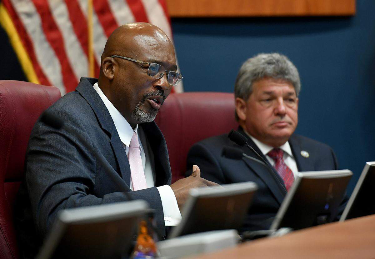 County Commissioner Reggie Bellamy speaks next to County Administrator Scott Hopes at a commission meeting where a vote approved Hopes’ contract renewal.