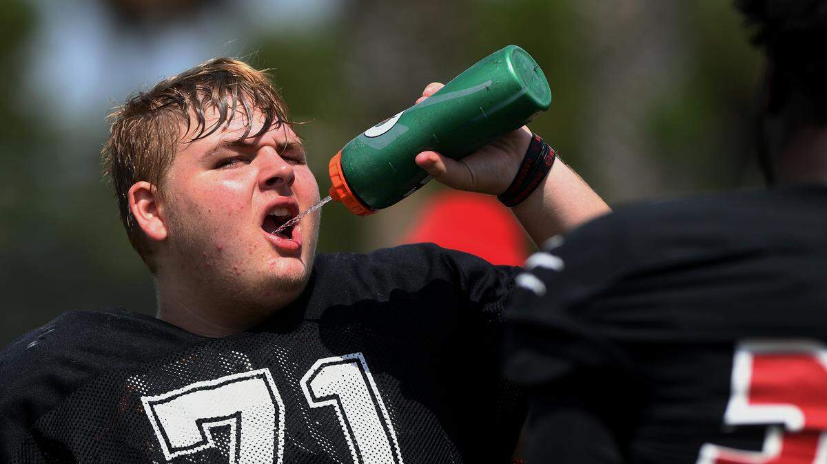 A player hydrates as varsity and jr. varsity took to Palmetto’s practice field August 17, 2022, with Coach Dave Marino in preparation for the season start of football.