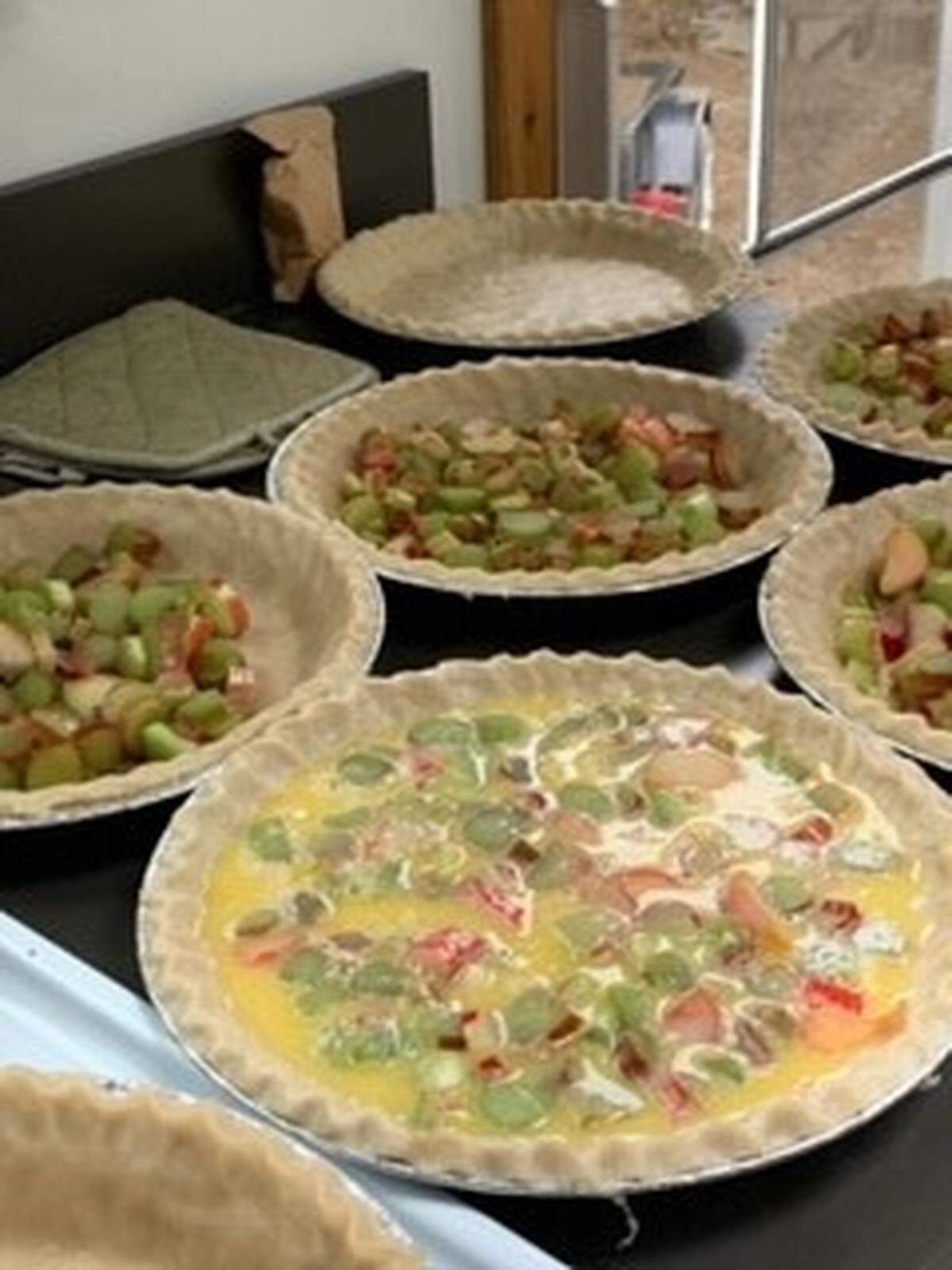 The women put together the many pies assembly-line style. Here, rhubarb pies are being assembled for baking.