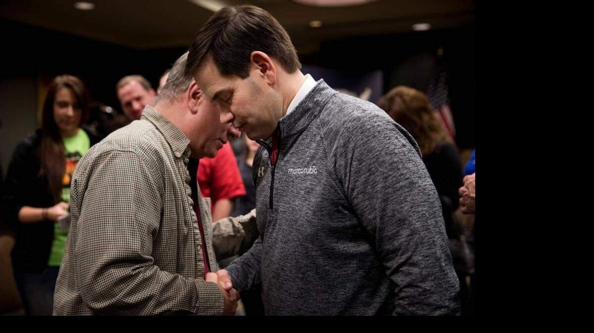 Republican presidential candidate Marco Rubio prays with Carl Hubbert after a rally Saturday in Council Bluffs, Iowa. JAE C. HONG AP