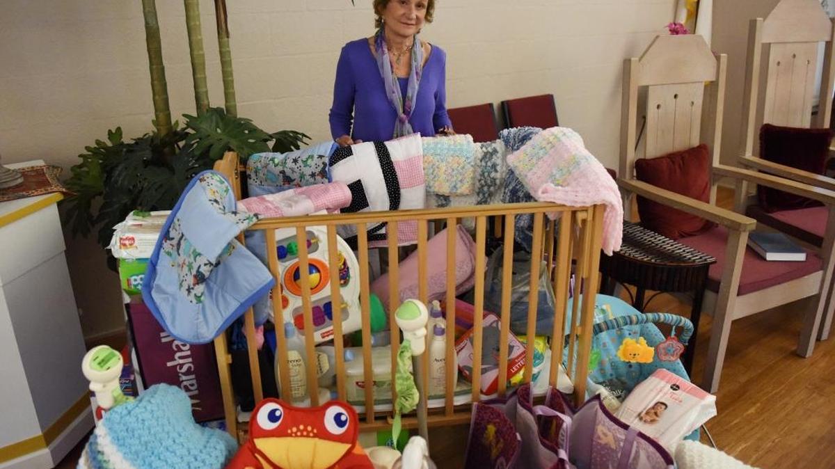 Nathalie Treonis stands next to a crib full of donated items for pregnant teenagers who attend Riverview High School. This is the third year the Longboat Island Chapel congregation has collected items for the teenagers and the 25th year they’ve given out scholarships for high school and college students.