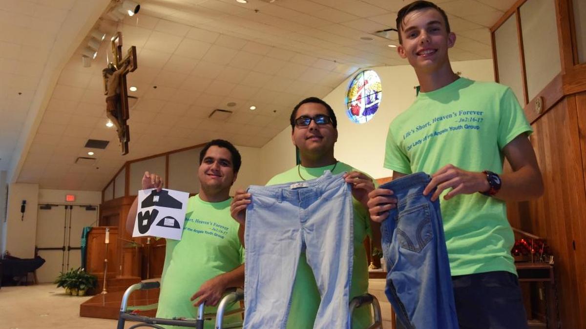 Twins Kyle and Justin Grejda, 17, and Mathew DiLorezo, 16, pose with used jeans and a shoe-making pattern at Our Lady of Angels. Their youth group will be collecting many items for children in Uganda and Kenya.