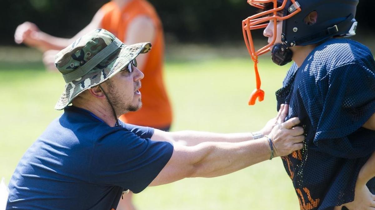 Bradenton Christian’s new head coach Dan Fort demonstrates proper blocking to his players as the Bradenton Christian School football team practices on Tuesday afternoon at Bradenton Christian School in Bradenton.