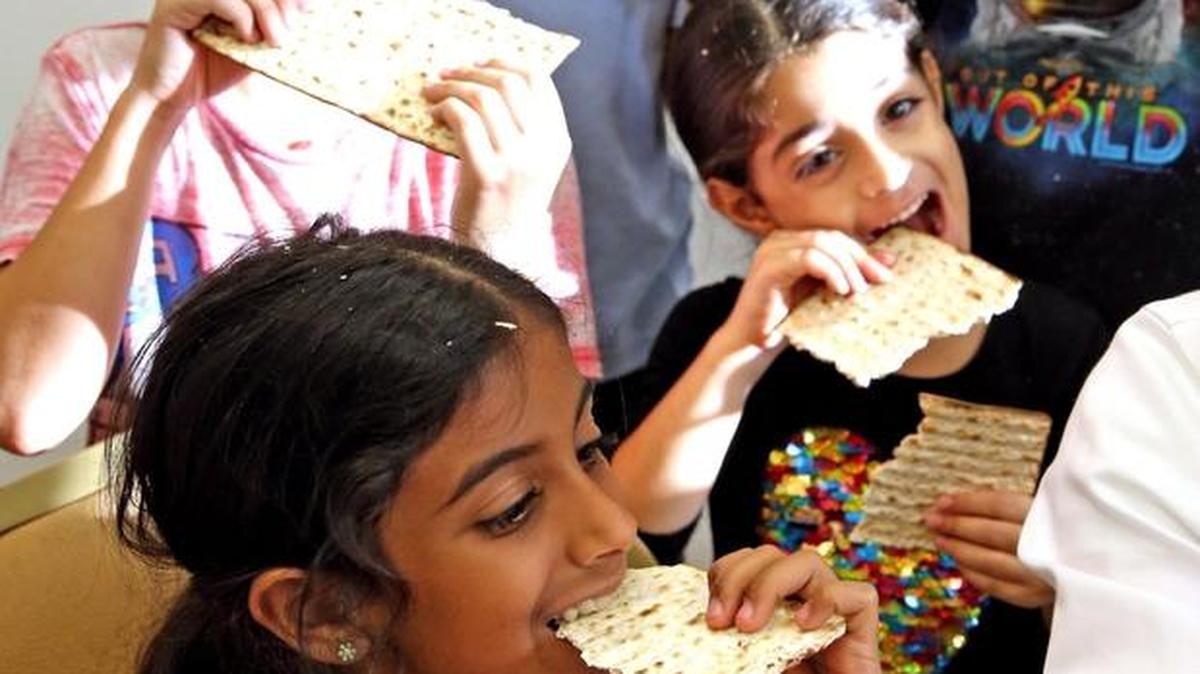 Talya Bachar 8, bites into a matzoh during Beit David Highland Lakes Shul’s mock Seder held by Rabbi Eliezer Wolf to educate children about Passover, April 6, 2017. The shul is located in Northeast Miami-Dade. Passover begins Monday night, April 10.