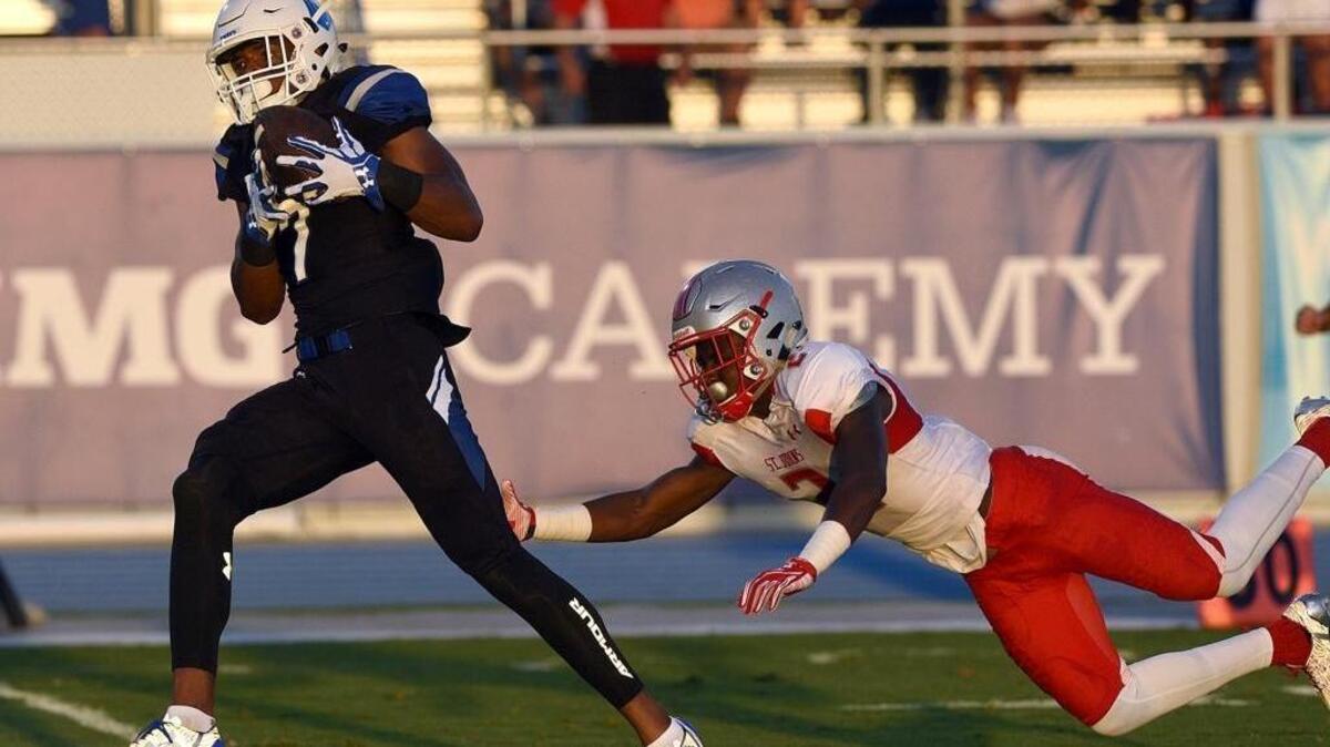 IMG's Brian Hightower runs for the goal line as he outruns St. Johns' DJ Brown at IMG's home game in Bradenton.