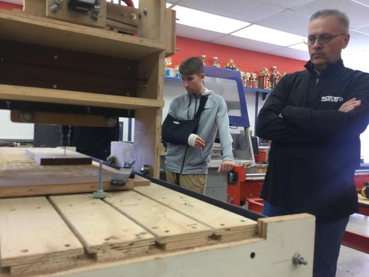 Southeast High School teacher Richard Platt and Student Engineering and Entrepreneurship Program student John Ferguson watch one of their creations in action. The students in the program, along with Platt have started a business that makes machines that makes machines as an effort to not only improve their community service goals, but to significantly reduce the costs of American manufacturing.