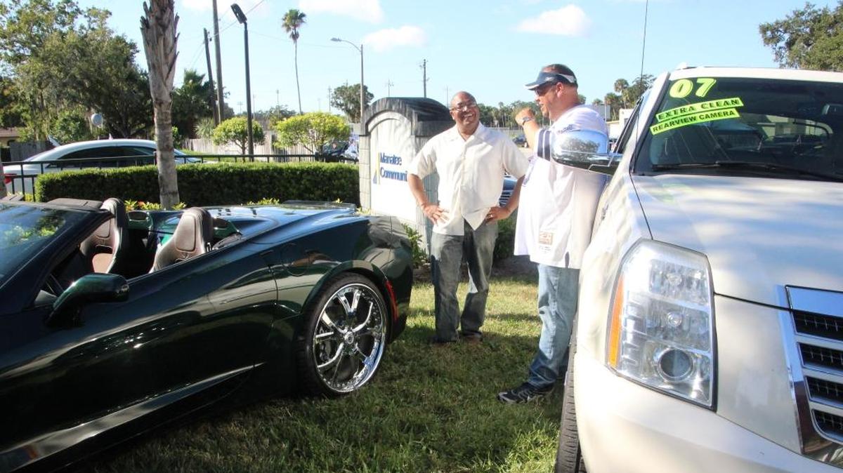 Sherod Halliburton, left, talks to Walter Spikes at a twice-a-year auto sales event in the Manatee Community Federal Credit Union parking lot.