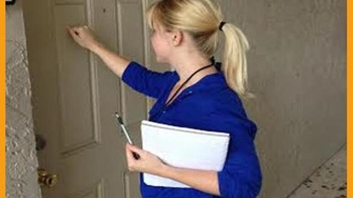 Erin Laird knocks on a door to conduct an oral survey on food deserts with residents.